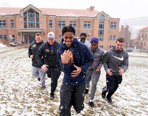 students playing a friendly game of football in the campus quad